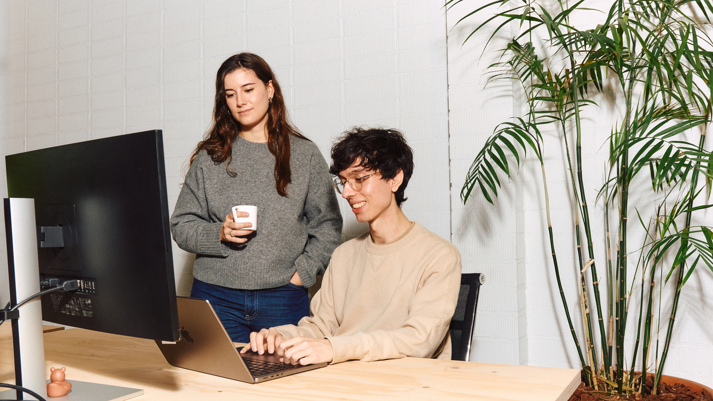 Ariadna and Carlo looking at a laptop.